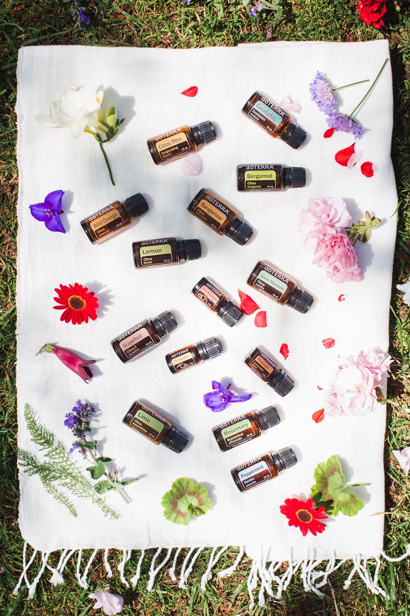 Essential oils for Energy laid out on a cotton towel, surrounded with flowers and petals