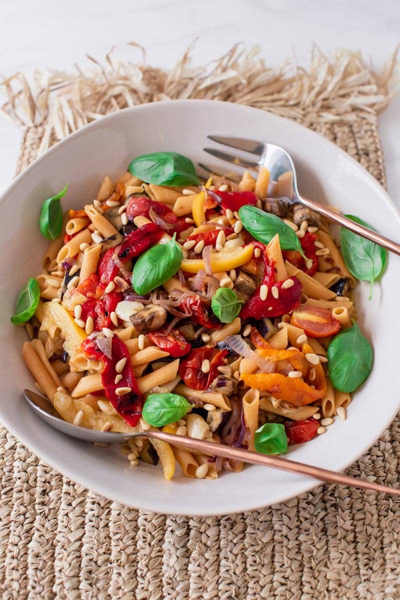 A large vibrant bowl of healthy pasta salad with roasted capsicum, eggplant and preserved lemon