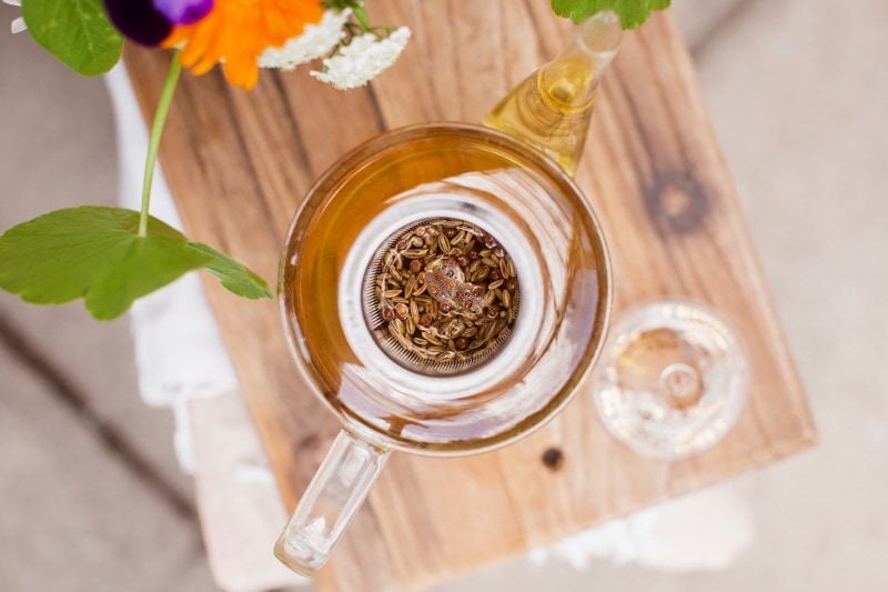 A glass tea pot with no lid, revealing aromatic spices steeping inside