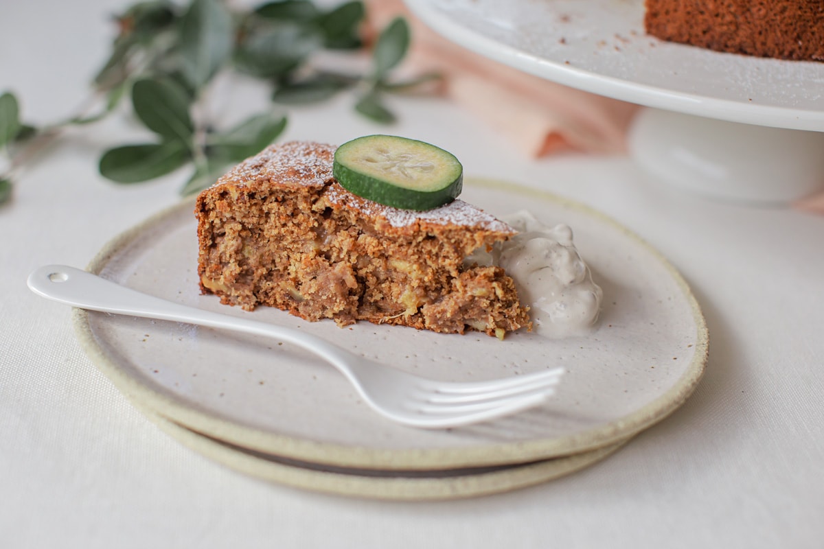 A slice of freshly baked cake with sliced feijoa on top.