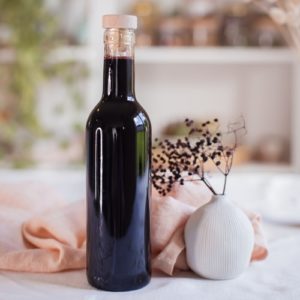 Bottle of elderberry syrup displayed beautifully on a table