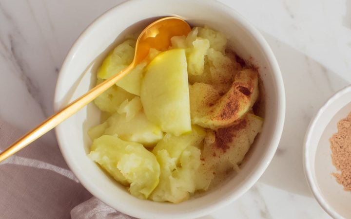 Ceramic bowl filled with stewed fruit and a dusting of cinnamon ready to enjoy.