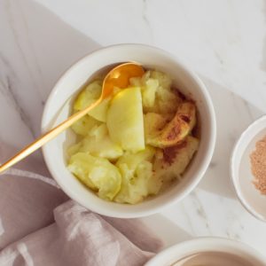 Bowl of stewed apples with a golden spoon