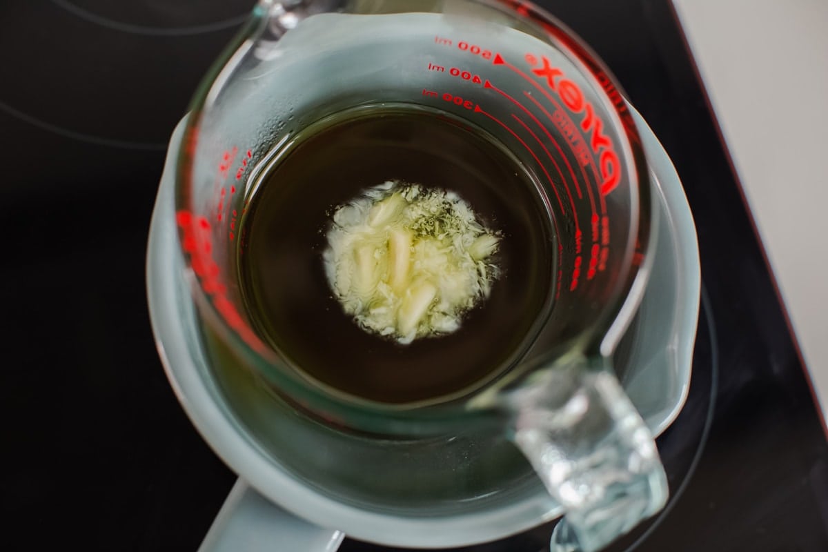 Overhead shot of the beeswax melting as the jug heats gently over a saucepan of simmering water.