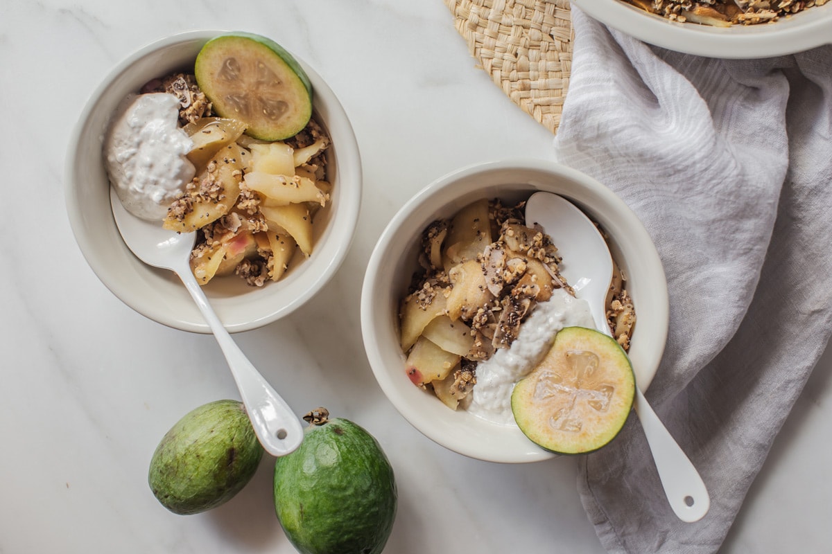 Two dessert bowls filled with hot crumble and a dollop of coconut yoghurt