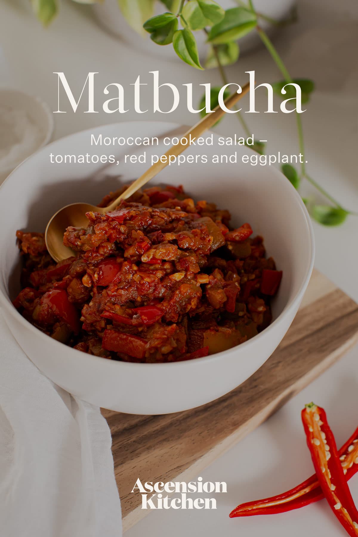 Hero shot of a vibrant bowl of matbucha on a wooden board, with the recipe title written over the top of the image.