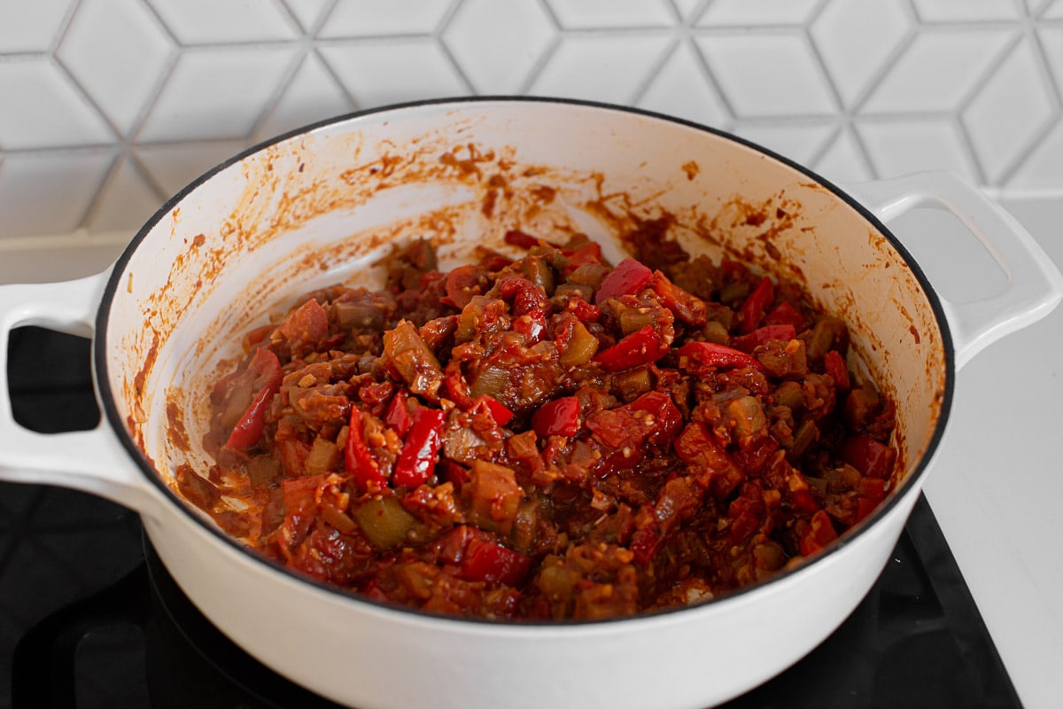 Tinned tomatoes have been added to the saucepan, the mixture reduced down 