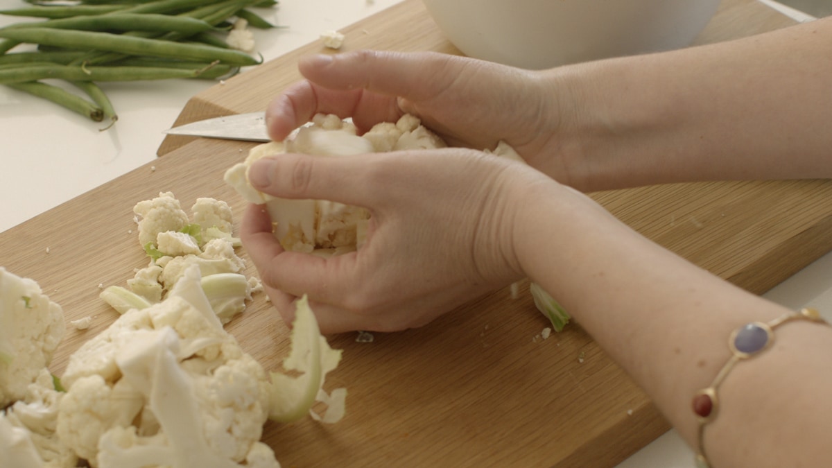 Lauren chopping fresh vegetables to add to add to the dish