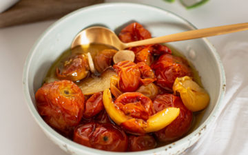 Ceramic bowl filled with juicy, blistered confit tomatoes