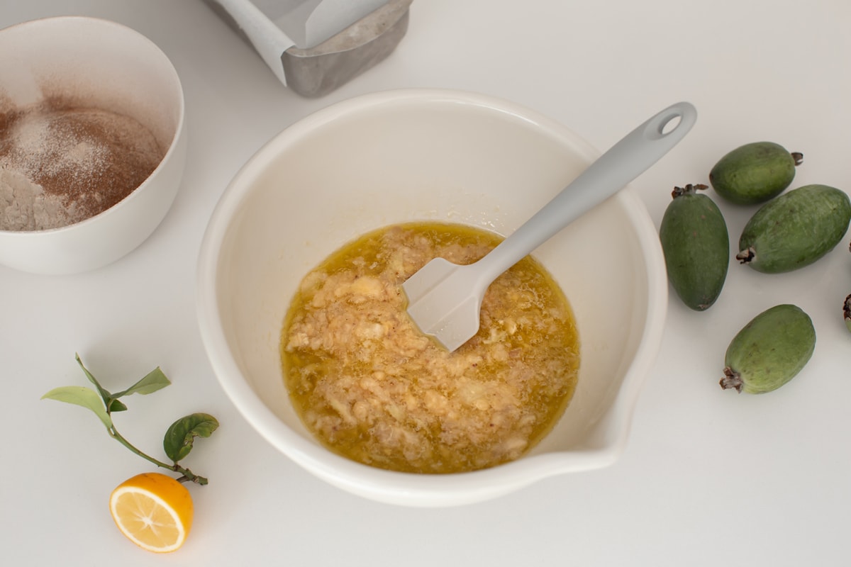 Large mixing bowl on kitchen bench filled with all wet ingredients.