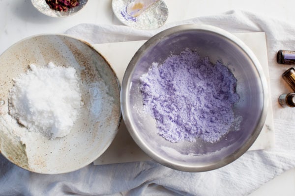 The bath bomb mixture has been divided into two bowls, with colouring added to one of them.