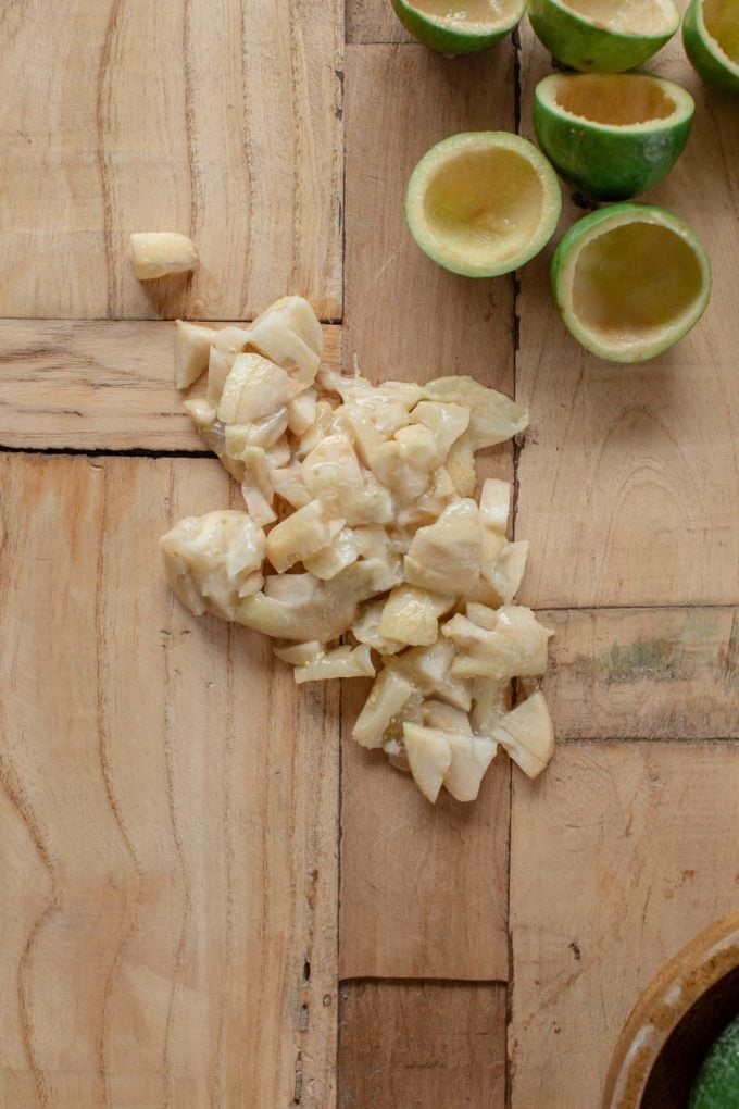 Freshly scooped and chopped feijoa fruit on a wooden board.
